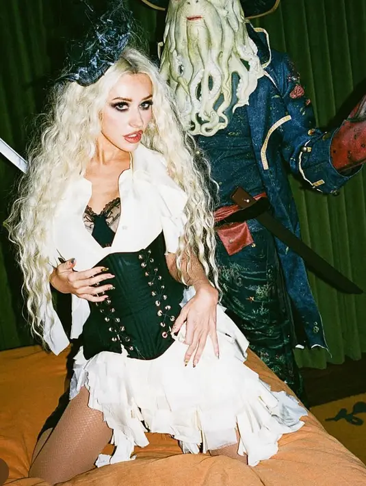 Christina Aguilera bertransformasi menjadi "Shipwreck-Tina". Ia memamerkan kostum Halloween bertema bajak laut, lengkap dengan hiasan kepala cetak 3D. Aguilera memadukannya dengan gaun putih tanpa lengan berumbai dan bra hitam berenda, serta korset, stoking jala, dan sepatu bot setinggi lutut. [@xtina]