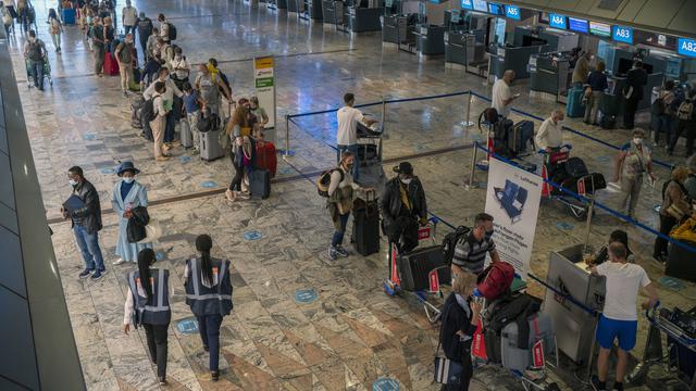 <span>Penumpang check-in di loket Lufthansa di bandara Johannesburg OR Tambo, Afrika Selatan (29/11/2021). Banyak negara memberlakukan larangan penerbangan terhadap negara-negara Afrika selatan karena kekhawatiran atas varian baru (Covid-19) Omicron. (AP/Jerome Delay)</span>