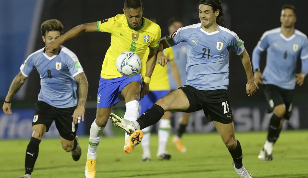 Bek Brasil, Renan Lodi mengontrol bola dari kawalan penyerang Uruguay, Edinson Cavani pada pertandingan keempat kualifikasi Piala Dunia 2022 zona CONMEBOL di Estadio Centenario, Montevideo, Selasa (17/11/2020). Brasil menang atas Uruguay 2-0. (AP Photo/Matilde Campodonico, Pool)