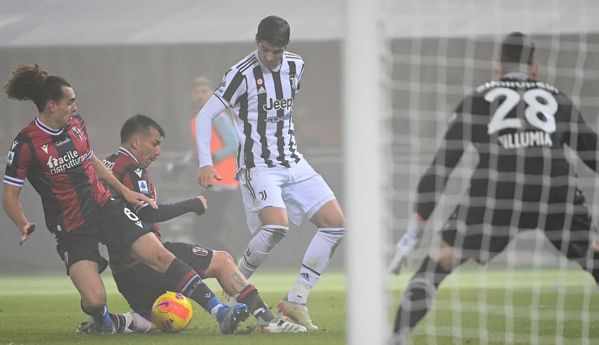 Penyerang Juventus Alvaro Morata (kanan) bersaing dengan pemain Bologna, Gary Medel dan Arthur Theate pada laga pekan ke-18 Liga Italia di Stadio Renato Dall'Ara, Minggu (19/12/2021) dini hari WIB. Bertamu ke markas Bologna, Juventus sukses mengalahkan tuan rumah 2-0. (Vincenzo PINTO/ AFP)