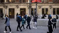Orang-orang dengan masker berjalan di Stasiun Pusat Amsterdam, Belanda, Rabu (3/11/2021). Belanda kembali menerapkan tindakan pembatasan virus corona, termasuk kewajiban memakai masker di berbagai ruang publik menyusul lonjakan kasus Covid-19 beberapa waktu terakhir. (Ramon van Flymen/ANP/AFP)