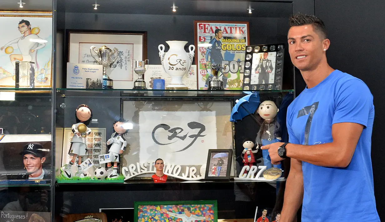 Cristiano Ronaldo memperlihatkan koleksinya di Museum CR7 di Funchal, Madeira, Portugal (23/7). Museum tersebut berisi perjalanan karier Ronaldo selama bertahun-tahun menggeluti dunia lapangan hijau. (AFP PHOTO/Helder Santos)