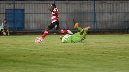 Pemain Madura United, Eric Weeks mengecoh Kiper Persiba Balikpapan, Alfonso pada laga Torabika SC 2016 di Stadion Gelora Bangkalan, Senin(13/6/2016).  (Bola.com/Nicklas Hanoatubun)
