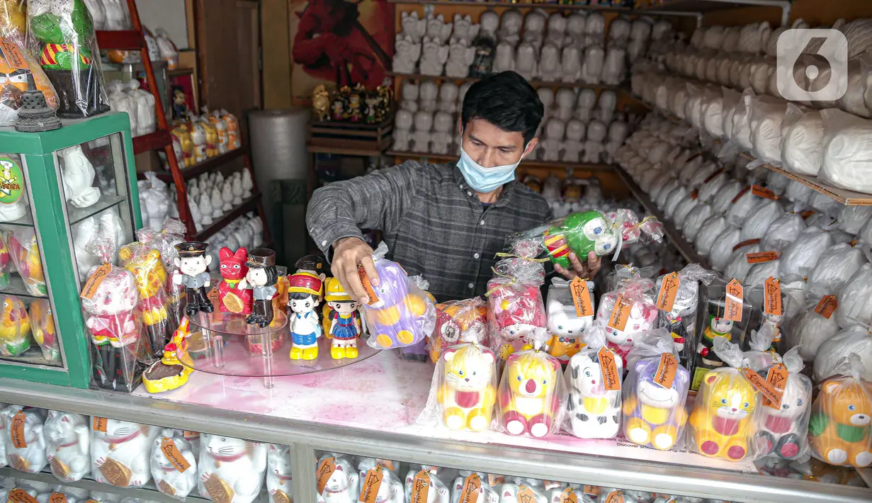 Pekerja memajang boneka karakter kartun di Saung Art Gallery, Pondok Cabe, Tangerang Selatan, Banten, Kamis (6/1/2022). Selain menjadi sarana edukasi, boneka berbahan gipsum yang dapat digunakan sebagai celengan ini dijual dengan harga Rp 20 ribu-Rp 40 ribu per buah. (Liputan6.com/Faizal Fanani)