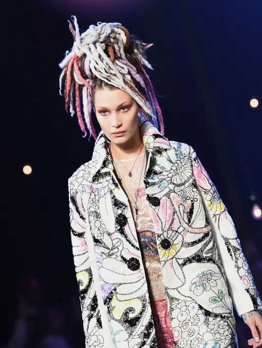 Bella Hadid, adik dari Gigi Hadid tampil di LFW 2016 menjadi salah satu model brand Versace untuk koleksi Spring/Summer 2017. Menyaksikan penampilan Bella, Gigi dan Zayn sempat menolehkan kepalanya ke kamera sambil tersenyum bahagia. (AFP/Bintang.com)