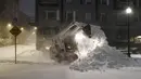 Sebuah frontend loader menghilangkan salju di Clipper Ship Wharf di lingkungan Boston Timur di Boston, Sabtu (29/1/2022). Orang-orang dari New York City hingga Maine terbangun karena salju tebal dan angin kencang saat badai Nor'easter yang kuat melanda. (AP Photo/Michael Dwyer)