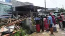 Orang-orang berada di depan rumah warga yang tertimpa beton akibat tergulingnya truk crane di Jalan Mawar, Perumnas Depok Jaya, Depok, Jawa Barat, Jumat (15/10/2021). (merdeka.com/Arie Basuki)
