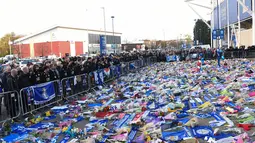 Pemain dan staf Leicester City (kiri) memberi penghormatan kepada korban kecelakaan helikopter yang menewaskan pemilik Leicester City Vichai Srivaddhanaprabha di luar Stadion King Power, Inggris, Senin (29/10). (Paul Ellis/AFP)