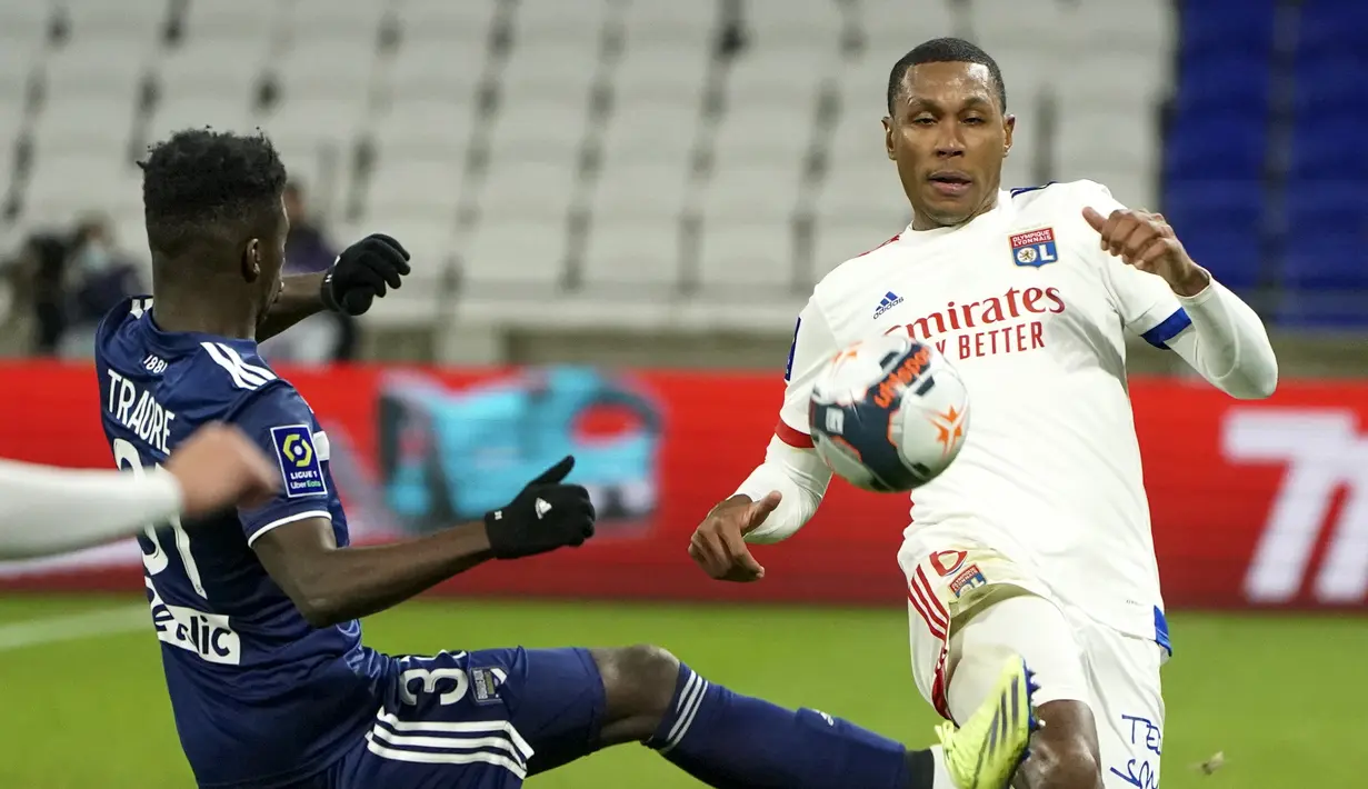 Striker Bordeaux, Amadou Traore (kiri) berebut bola dengan bek Lyon, Marcelo dalam laga lanjutan Liga Prancis 2020/21 pekan ke-22 di Groupama Stadium, Jumat (29/1/2021). Bordeaux kalah 1-2 dari Lyon. (AP/Laurent Cipriani)