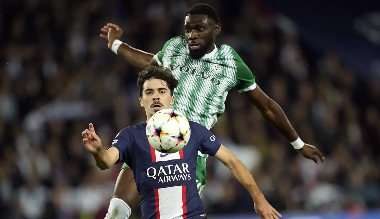 Gelandang Paris Saint Germain (PSG) Vitinha berebut bola dengan bek Maccabi Haifa, Dylan Batubinsika pada matchday kelima Grup H Liga Champions 2022/23 di Parc des Princes, Rabu (26/10/2022) dinihari WIB. Berkat hasil ini, PSG memuncaki klasemen Grup H dengan poin 11 sekaligus berhak lolos ke 16 besar. (AP Photo/Christophe Ena)