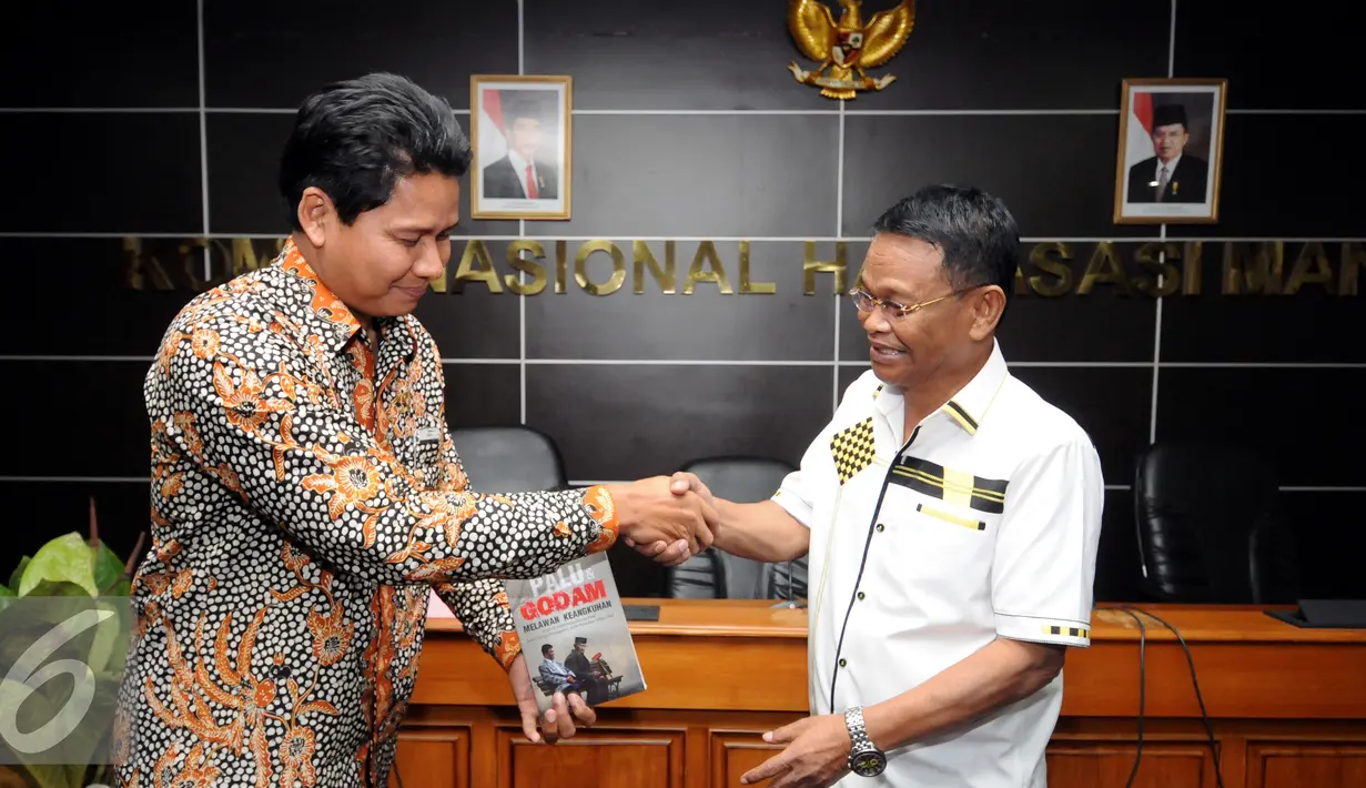 Ketua Komnas HAM, Imdadun Rahmat (kiri) menerima buku Palu dan Godam Melawan Keangkuhan dari Rusdy Mastura di Jakarta, Rabu (29/6). Buku itu kisah di balik permohonan maaf kepada korban pelanggaran HAM 1965-1966. (Liputan6.com/Helmi Fithriansyah)