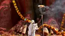 Seorang imam menyalakan api untuk berdoa dalam perayan Jain Festival di Shravanabelagola, di barat Bangalore, India (18/2). (AP Photo/Aijaz Rahi)