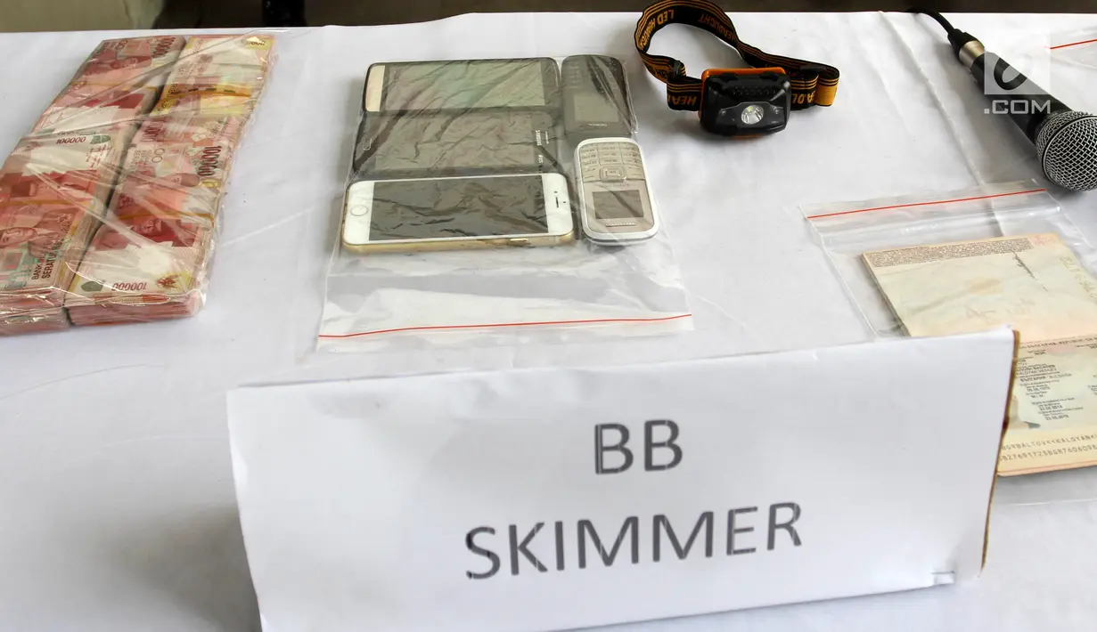 Sejumlah barang bukti pemalsuan dan pencurian data elektronik (skimming) di Polda Metro Jaya, Jakarta, Senin (19/3). Polisi menyita 196 kartu ATM, dua alat deep skimmer, laptop, paspor, dan uang tunai Rp 50 juta. (Liputan6.com/Arya Manggala)
