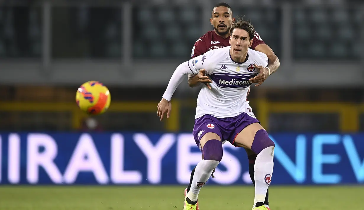 Penyerang Fiorentina, Dusan Vlahovic berebut bola dengan pemain Torino, Bremer selama pertandingan lanjutan Liga Serie A Italia di stadion Olimpiade di Turin, Italia, Selasa (11/1/2022). Torino menang telak atas Fiorentina 4-0. (Fabio Ferrari/LaPresse via AP)