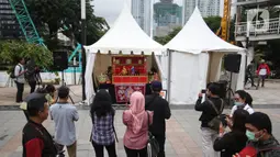 Masyarakat tengah melihat pagelaran wayang potehi di Taman Budaya Dukuh Atas, Jakarta, Jumat (7/2/2020). Pagelaran pertunjukan wayang Tionghoa ini merupakan rangkaian kebudayan imlek yang di gelar oleh Pemprov DKI Jakarta. (Liputan6.com/Angga Yuniar)