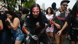 Seorang pria memakai kostum dan dandanan menyerupai zombie dalam acara Zombie Walk di pantai Copacabana, Rio de Janeiro, Brasil, Jumat (2/11). Ribuan orang ini beraksi sebagai Zombie untuk memeriahkan peringatan Hari Para Arwah. (Mauro PIMENTEL/AFP)