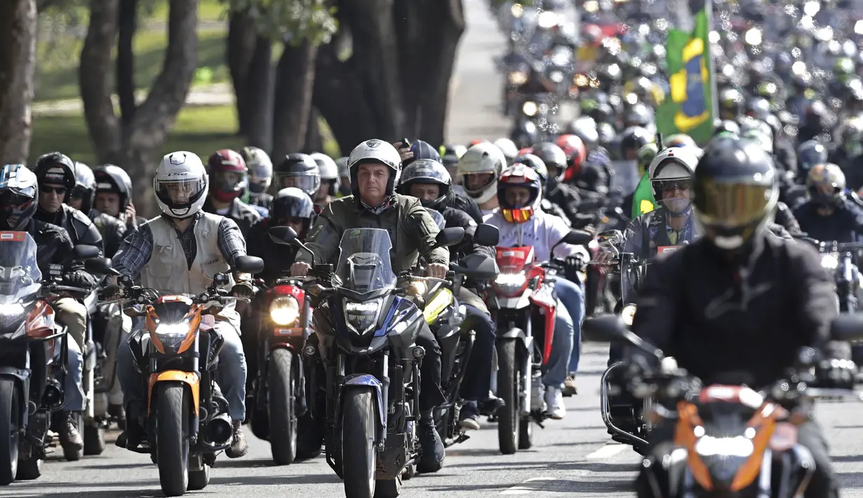 Presiden Brasil Jair Bolsonaro (kiri tengah) melakukan tur sepeda motor dengan para pendukung di Brasilia, di tengah pandemi COVID-19, Minggu (9/5/2021). Bolsonaro memimpin ratusan pengendara motor melakukan perjalanan mengelilingi ibu kota Brasil untuk memperingati Hari Ibu. (AP Photo/Eraldo Peres)