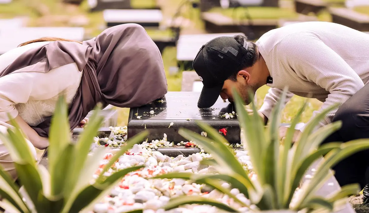 Salah satu foto yang menarik pertahian adalah saat Thariq dan Aaliyah Massaid menciun nisan Adie Massaid untuk meminta restu.