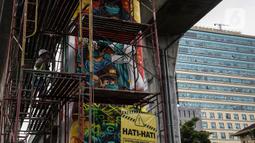 Seniman melukis tiang jalan layang di kawasan Lapangan Bhayangkara, Mabes Polri, Jakarta, selasa (2/11/2021). Selama ini seni mural kurang mendapatkan tempat di fasilitas-fasilitas umum dan Pembuatan Mural ini bagian dalam rangka Bhayangkara Mural Festival 2021. (Liputan6.com/Johan Tallo)