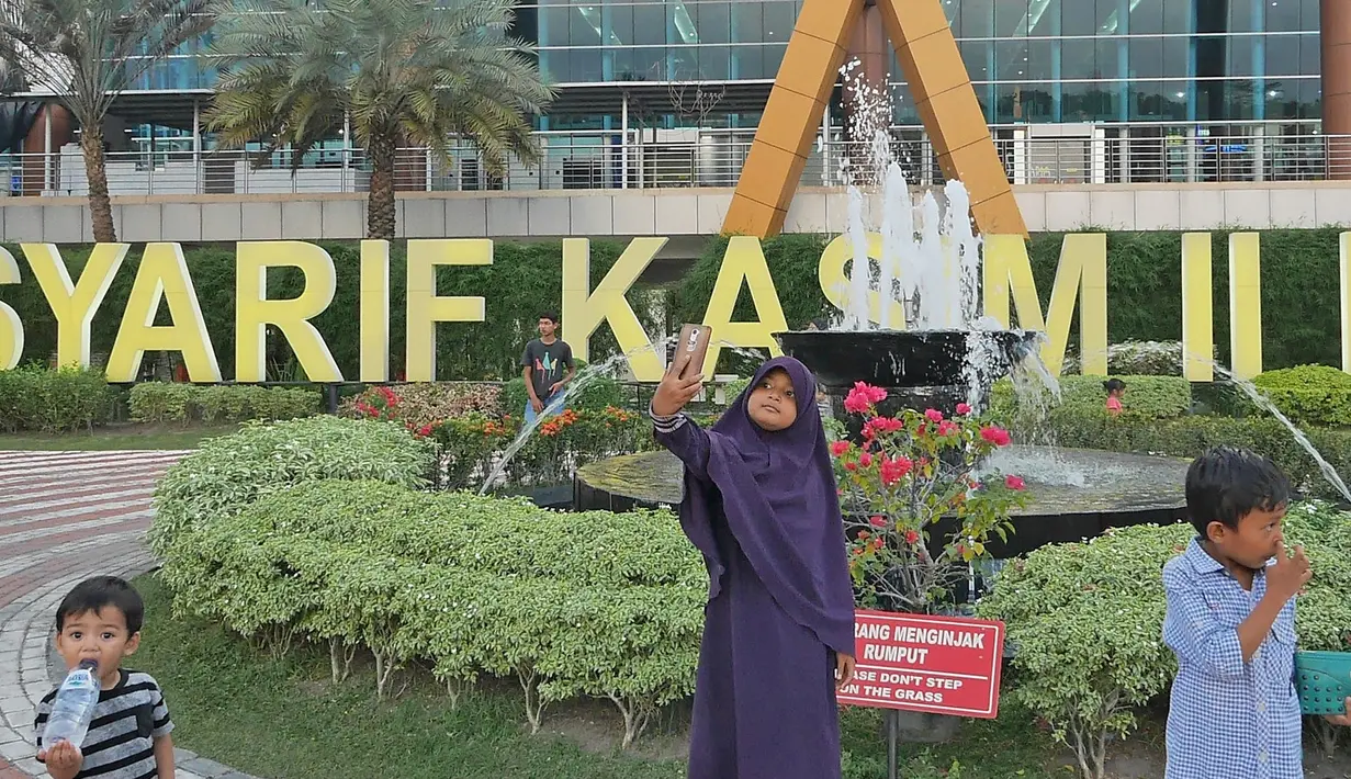 Anak-anak bermain di taman Bandara Sultan Syarif Kasim II Pekanbaru, Riau, Rabu (9/5). Penggunaan Bahasa Melayu di tempat umum masuk dalam kategori muatan lokal budaya Melayu nonpendidikan. (Liputan.com/Herman Zakharia)