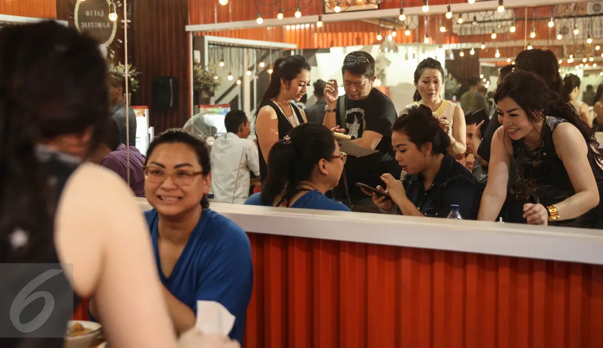 Para pemilik sibuk melayani pengunjung di Warung Bakso Djingkrak Sunter, Jakarta, Kamis (28/4). Warung bakso ini sempat menjadi perbincangan dunia maya lantaran ada wanita-wanita seksi yang ikut melayani pelanggan (Liputan6.com/Faizal Fanani)