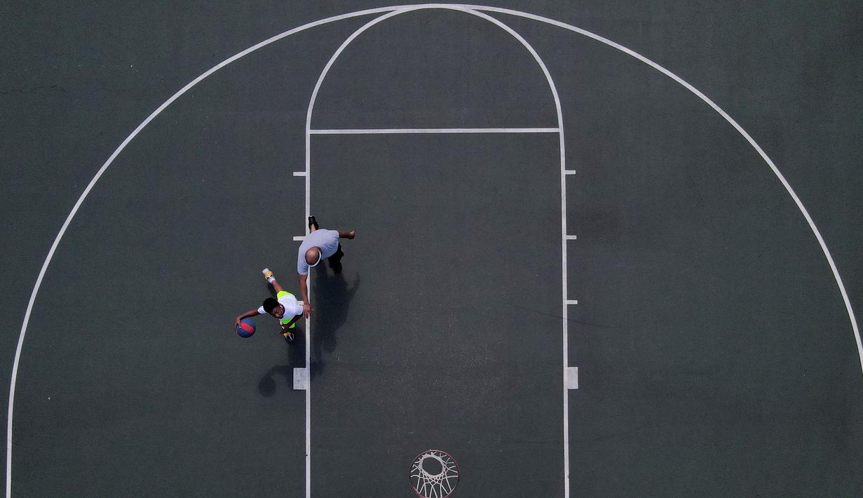 Cam Norman Jr (kiri) bersama ayahnya  Cam Norman Sr bermain basket di Sekolah Dasar Internasional Padonia, Cockeysville, Maryland, Amerika Serikat, Rabu (1/7/2020). (AP Photo/Julio Cortez)