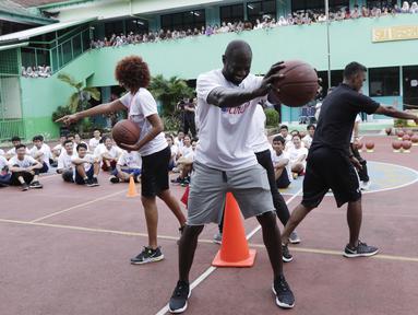 Legenda NBA, Jason Richardson, memberikan pelatihan kepada siswa SMA 82 Jakarta, Kamis (28/3). Kunjungan peraih dua gelar juara kontes slamdunk NBA tersebut merupakan bagian dari rangkaian program Jr NBA. (Bola.com/M Iqbal Ichsan)