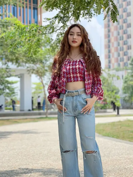 <p>Jeans sebagai celana andalan banyak orang bisa dipadu untuk outfit feminin. Gunakan crop top berwarna cerah untuk menambah tampilan girly yang fresh. [Instagram/natashawilona12]</p>