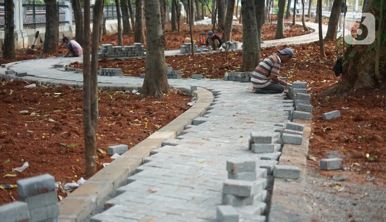 Pekerja menyelesaikan pembuatan jogging track di Taman Citra PPSU Srengseng Sawah, Jakarta, Rabu (4/12/2019). Jogging track tersebut dibuat guna meningkatkan kenyamanan bagi warga yang ingin beraktivitas di taman tersebut. (Liputan6.com/Immanuel Antonius)