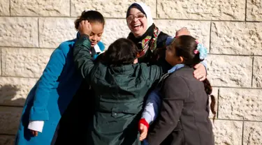 Seorang guru dengan Down Syndrome yang bernama Hiba Al-Sharfa bermain dengan muridnya di sekolah Asosiasi Hak Hidup di Kota Gaza (21/12). Hiba adalah seorang guru yang memeliki “kebutuhan khusus” di Jalur Gaza. (Reuters/Suhaib Salem)