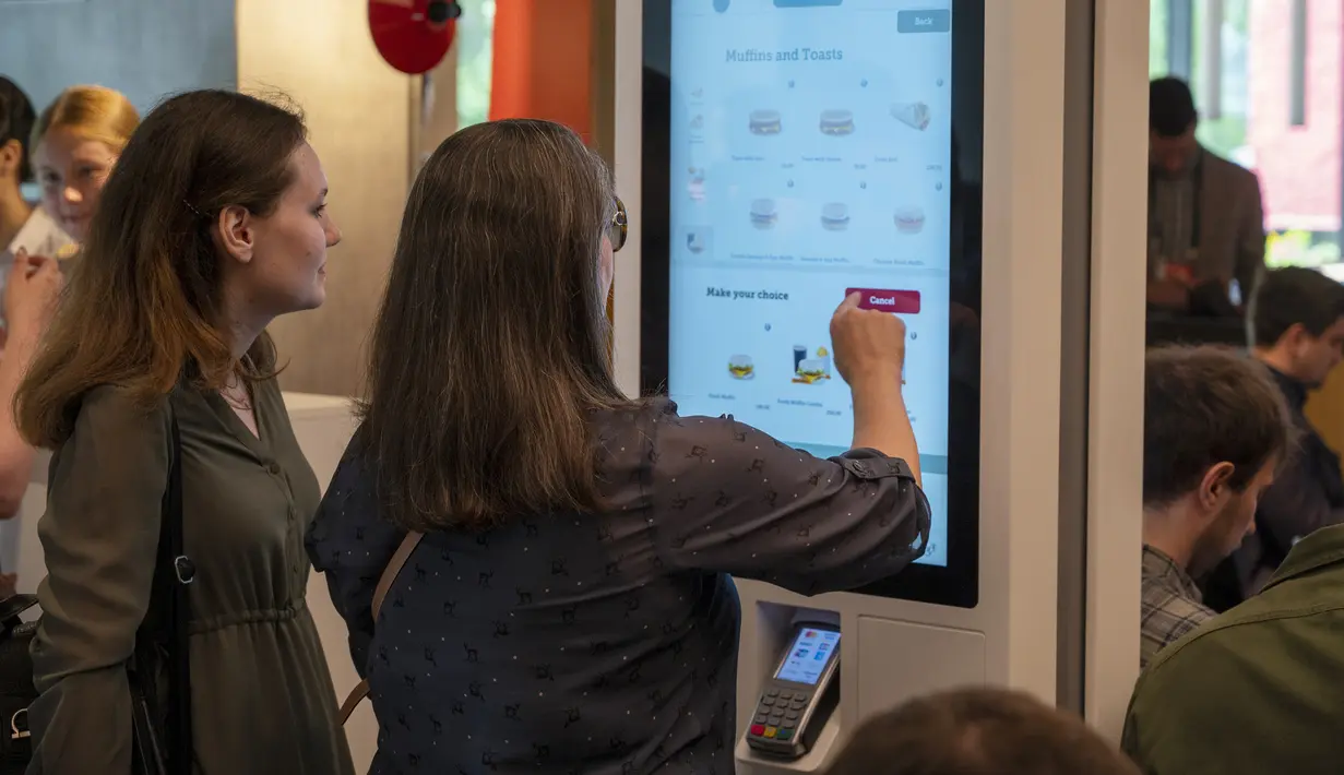 Pengunjung memesan makanan di restoran cepat saji yang baru dibuka di bekas gerai McDonald's di Bolshaya Bronnaya Street, Moskow, Rusia, 12 Juni 2022. Korporasi menjual cabangnya di Rusia ke salah satu pemegang lisensi lokal setelah Rusia mengirim puluhan ribu tentara ke Ukraina. (AP Photo/Dmitry Serebryakov)