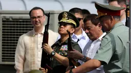 Presiden Filipina Rodrigo Duterte (kedua kanan) memeriksa senapan serbu AK-47 Kalashnikov sumbangan dari Rusia di atas kapal perusak Rusia Admiral Panteleyev di pelabuhan Metro Manila, Filipina (25/10). (AFP Photo/Robinson Ninal)