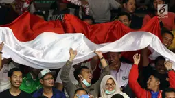 Suporter membentangkan bendera saat menyaksikan laga Indonesia melawan Qatar di Kejuaraan Voli Asia 2017 di GOR Tri Dharma, Gresik, Rabu (26/7). Indonesia unggul 3-2 (24-26, 14-25, 25-20, 25-21, 15-11). (Liputan6.com/Helmi Fithriansyah)