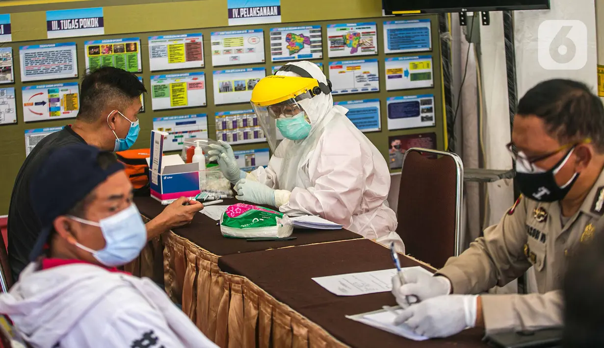 Petugas medis melakukan rapid test gratis kepada warga di Pos Pengamanan Natal 2020 dan Tahun Baru 2021 Polsek Kebayoran Lama, Jakarta, Selasa (29/12/2020). Rapid test itu dilakukan untuk membantu mengurai antrean warga saat tes di tempat lainnya. (Liputan6.com/Faizal Fanani)