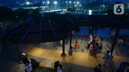 Pengunjung menikmati suasana di Skywalk Senayan Park, Jakarta, Rabu (29/12/2021). Tempat yang dulu dikenal dengan nama Taman Ria Senayan di era 70-80 an kini berganti konsep menjadi Senayan Park (SPARK). (merdeka.com/Imam Buhori)