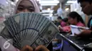 Petugas menunjukan uang pecahan US$100 di penukaran uang Jakarta, Senin (24/8/2015). Nilai tukar rupiah terhadap dolar Amerika Serikat (AS) terus menguat, Posisi dolar terus beranjak hingga di kisaran Rp 14.150. (Liputan6.com/Johan Tallo)