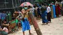 Seorang pria memegang tabung oksigen sambil menunggu di luar pabrik oksigen Naing di kawasan industri South Dagon di Yangon, Myanmar, Rabu (28/7/2021). Myanmar saat ini dilanda lonjakan jumlah kasus COVID-19 dan kematian yang sangat membebani infrastruktur medis negara itu. (AP Photo)