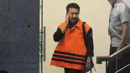 Ekspresi Bupati Jombang Nyono Suharli Wihandoko dikawal petugas berjalan keluar usai menjalani pemeriksaan perdana di Gedung KPK, Jakarta, Rabu (7/2). Nyono ditangkap terkait promosi jabatan di Pemkab Jombang. (Liputan6.com/Herman Zakharia)