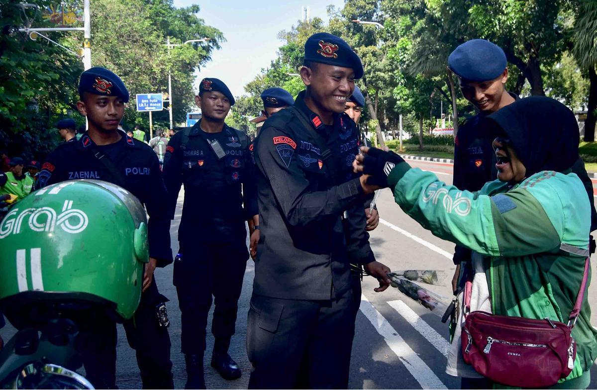 FOTO: Aksi Damai Ojol Tebar Mawar untuk Perdamaian