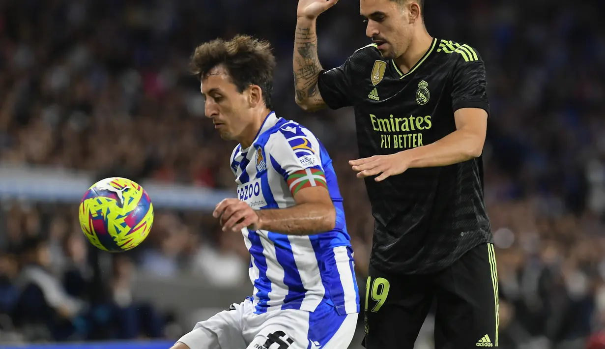Gelandang Real Madrid Dani Ceballos berebut bola dnegan penyerang Real Sociedad  Mikel Oyarzabal pada pekan ke-33 Liga Spanyol 2022/2023 di Reale Arena, Rabu (3/5/2023) WIB.  (AP Photo/Alvaro Barrientos)