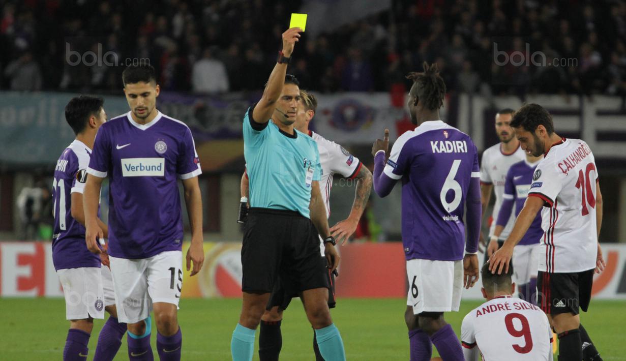 Wasit memberi kartu kuning kepada bek Austria Wien, Mohammed Kadiri, karena melanggar striker AC Milan, Andre Silva, pada laga Liga Europa di Stadion Stadion Ernst Happel, Wien, Kamis (14/9/2017). Wien kalah 1-5 dari Milan. (Bola.com/Reza Khomaini)