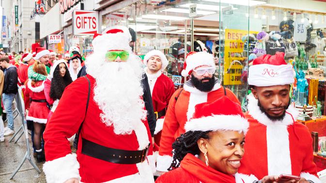 Orang-orang yang berpakaian seperti Sinterklas mengantre untuk memasuki bar dalam acara tahunan Santacon di New York City, Sabtu (14/12/2019). Dalam acara tersebut, peserta berkeliling bar untuk menyambut datangnya liburan Natal. (Gabby Jones/Getty Images/AFP)