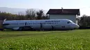Dua wanita membersihkan badan pesawat Fokker-100 di halaman rumah warga setempat di Strmec Stubicki, Kroasia, 26 Oktober 2019. Pesawat yang membujur di kebun Robert Sedlar (50) itu merupakan buatan 1991 dan beroperasi melayani penerbangan komersial di Kroasia sampai 2014. (Denis LOVROVIC / AFP)