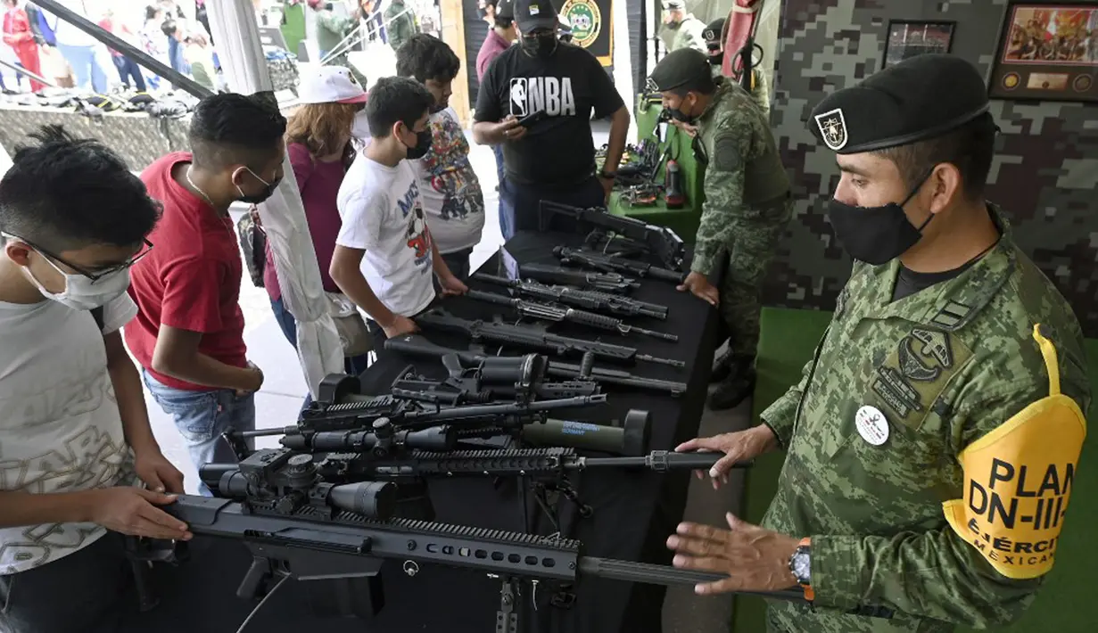 Orang-orang mengamati berbagai senjata yang digunakan oleh Tentara Meksiko dalam pameran yang disebut The Great Force of Mexico di Alun-Alun Zocalo, Mexico City, Meksiko, 20 September 2021. (ALFREDO ESTRELLA/AFP)