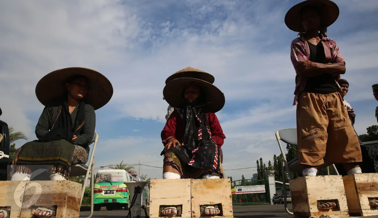 Sejumlah warga Petani Kendeng, Pati, Jawa Tengah, menggelar aksi di depan Istana Negara, Jakarta, Senin (13/3). Aksi ini merupakan aksi yang ketiga yang dilakukan warga Kendeng. (Liputan6.com/Johan Tallo)