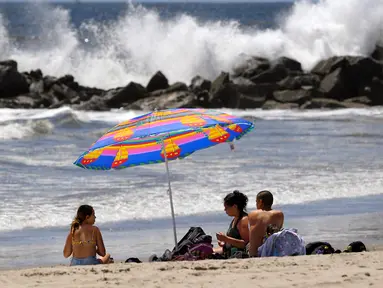 Para pengunjung duduk di Pantai Venice di Los Angeles (13/5/2020). Los Angeles County membuka kembali pantai-pantainya pada Rabu dalam pelonggaran terbaru pembatasan coronavirus yang telah menutup sebagian besar ruang publik dan bisnis California selama hampir dua bulan. (AP/Mark J. Terrill)