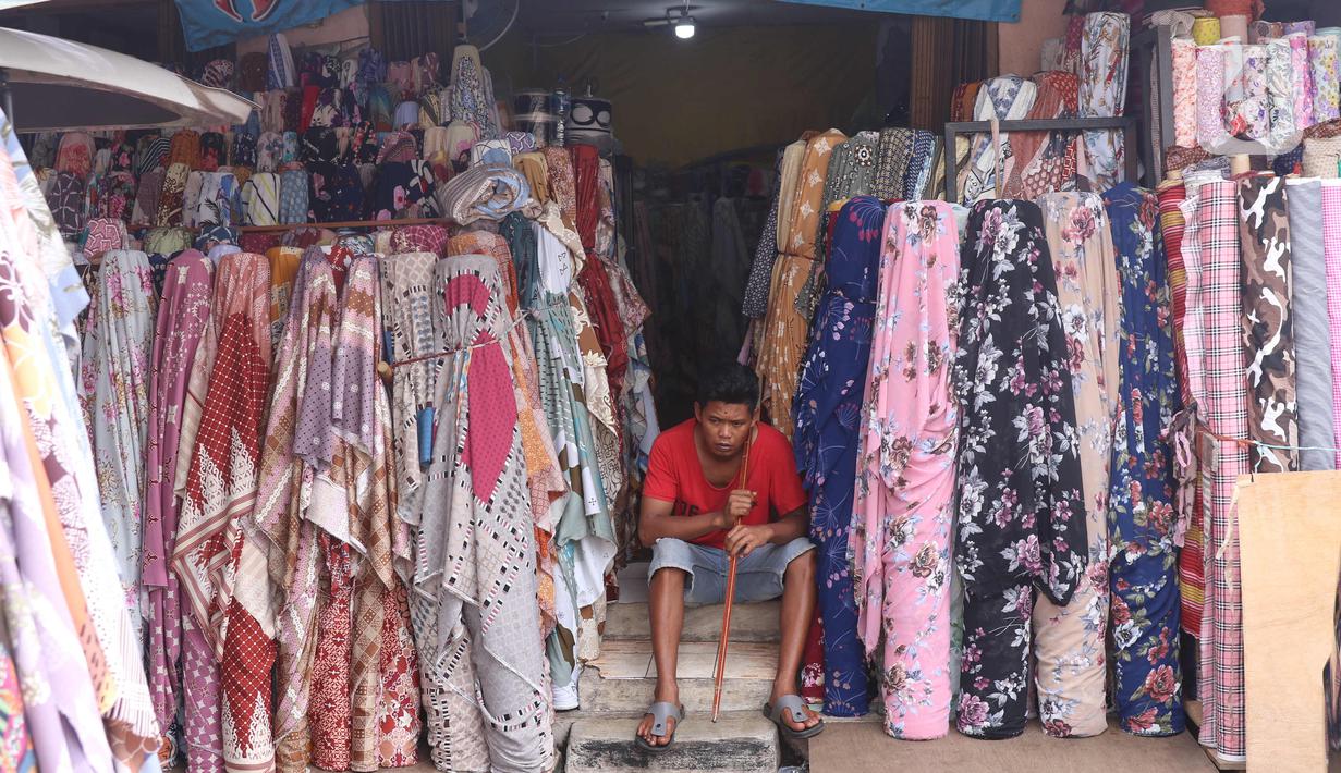Pekerja menunggu pembeli di salah satu toko di Pasar Cipadu, Tangerang, Selasa (2/3/2021). Pandemi Covid-19 membuat industri tekstil dan pakaian jadi mengalami pertumbuhan negatif 8, 8 persen sepanjang 2020 dengan kinerja ekspor yang berkontraksi 17 persen. (Liputan6.com/Angga Yuniar)