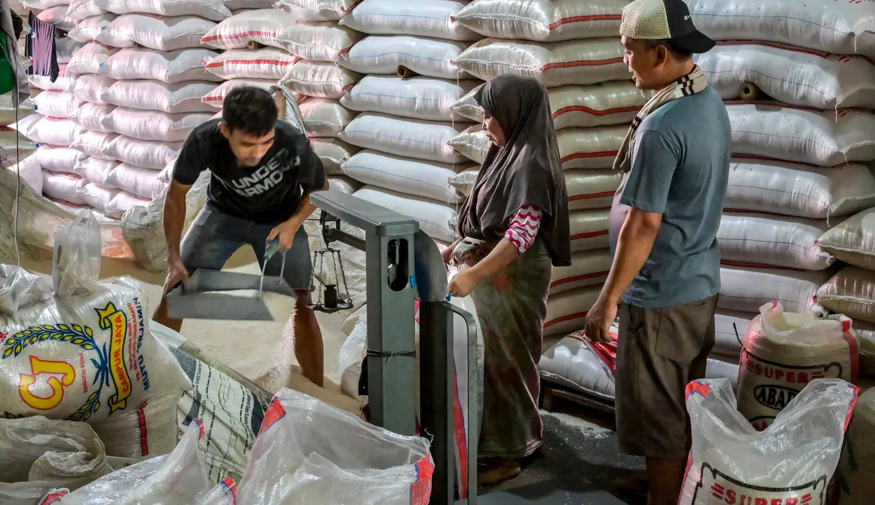 Para pekerja menyiapkan pesanan pelanggan di pasar beras utama di Jakarta pada Rabu 9 Juli 2025. (BAY ISMOYO/AFP)