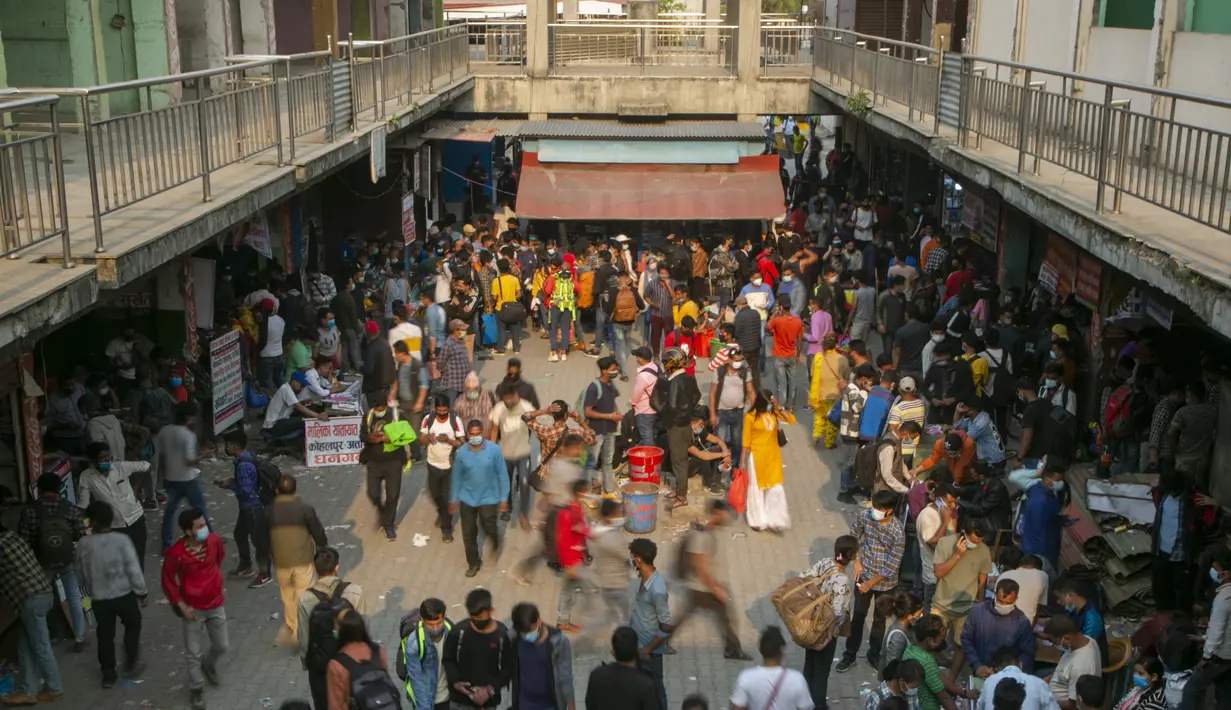 Orang-orang tiba di terminal bus yang ramai untuk kembali ke desanya sehari sebelum lockdown di Kathmandu, Rabu (28/4/2021). Puluhan ribu orang meninggalkan ibu kota Nepal sehari menjelang lockdown selama 15 hari yang diberlakukan karena melonjaknya kasus COVID-19. (AP Photo/Niranjan Shrestha)
