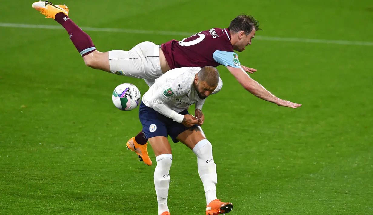 Bek Manchester City, Kyle Walker berebut bola dengan pemain  Burnley, Ashley Barnes pada laga babak keempat Piala Liga Inggris di Turf Moor, Kamis (1/10/2020) dini hari WIB. Raheem Sterling mencetak dua gol saat Manchester City menang 3-0 atas Burnley. (Paul Ellis/Pool via AP)